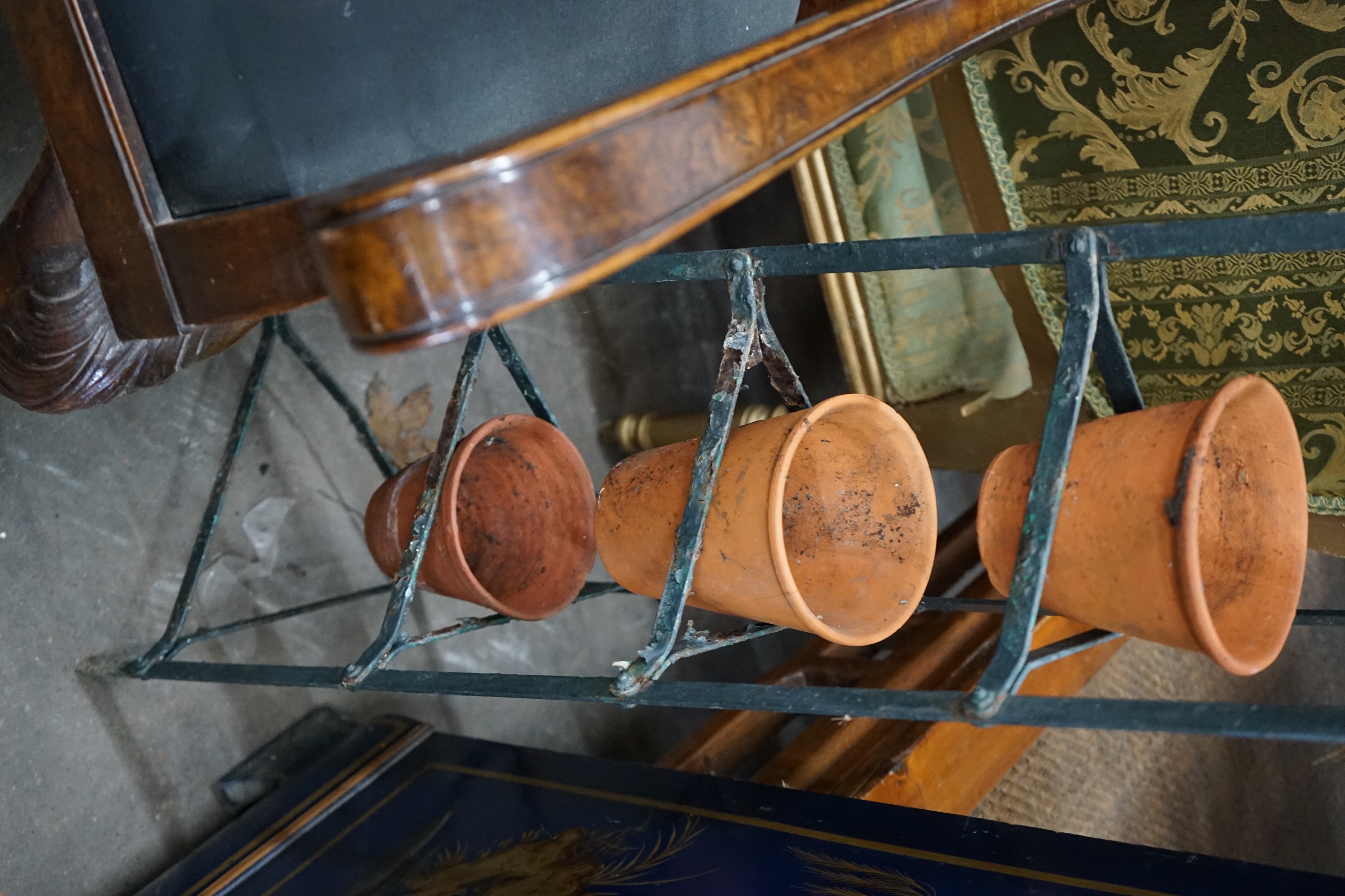 A wrought iron six tier pot stand, together with six terracotta pots, height 143cm